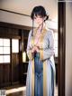 A woman in a blue and white kimono standing in a room.