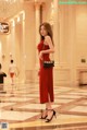 A woman in a red dress standing in a lobby.